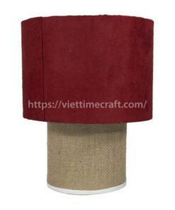 A table lamp with a red fabric shade and a jute-covered base